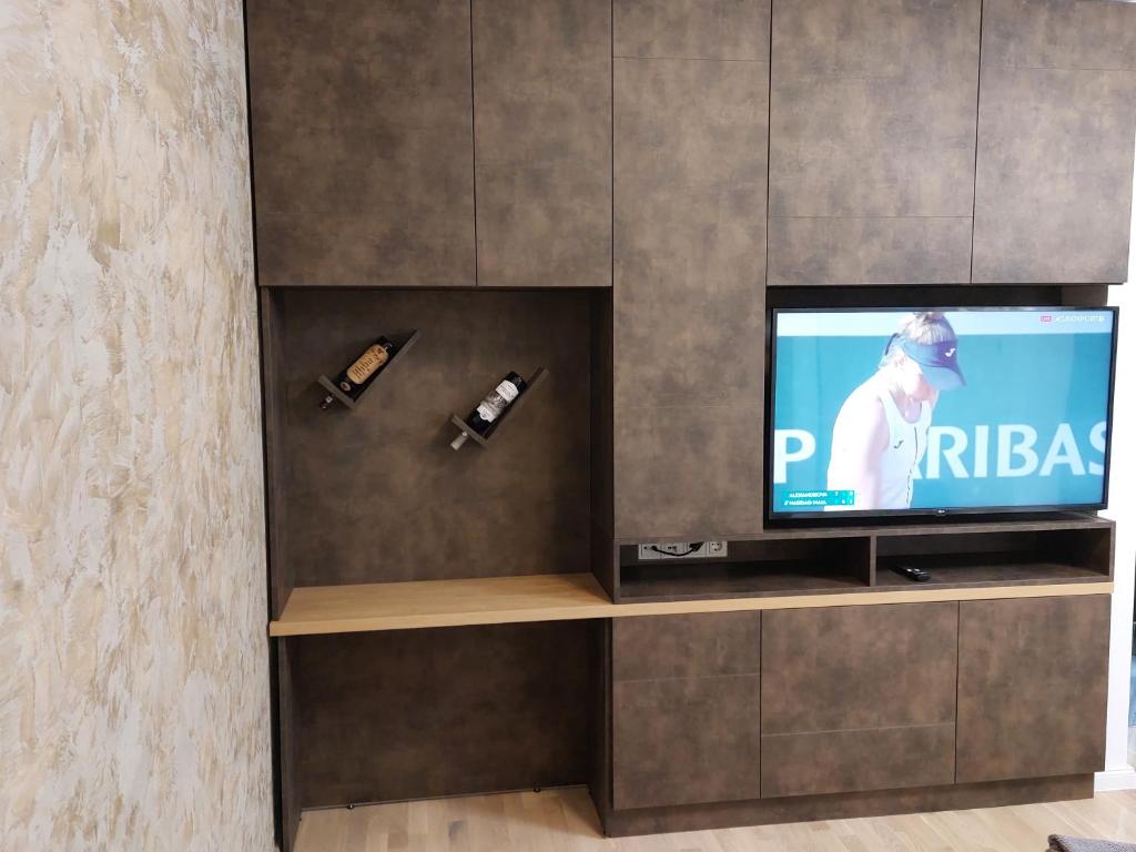 een tv op een plank in een kamer bij Cosmopolit by Riba in Braşov