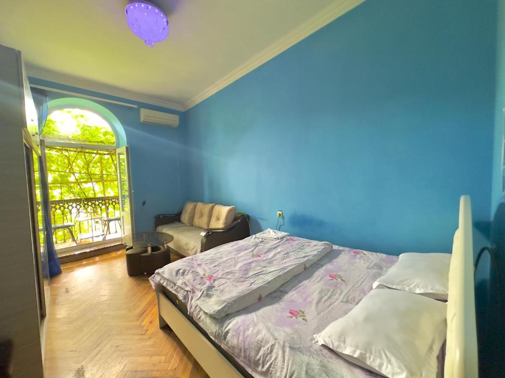 1 dormitorio con 1 cama, 1 silla y 1 ventana en KARSON FAMILY HOSTEL & GUEST HOUSE, en Ereván
