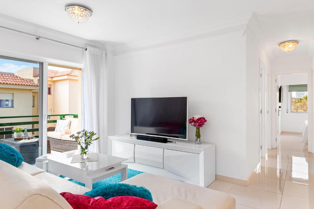 a white living room with a tv and a couch at CristiSmart Home Hi-End Services Media Streaming in Los Cristianos