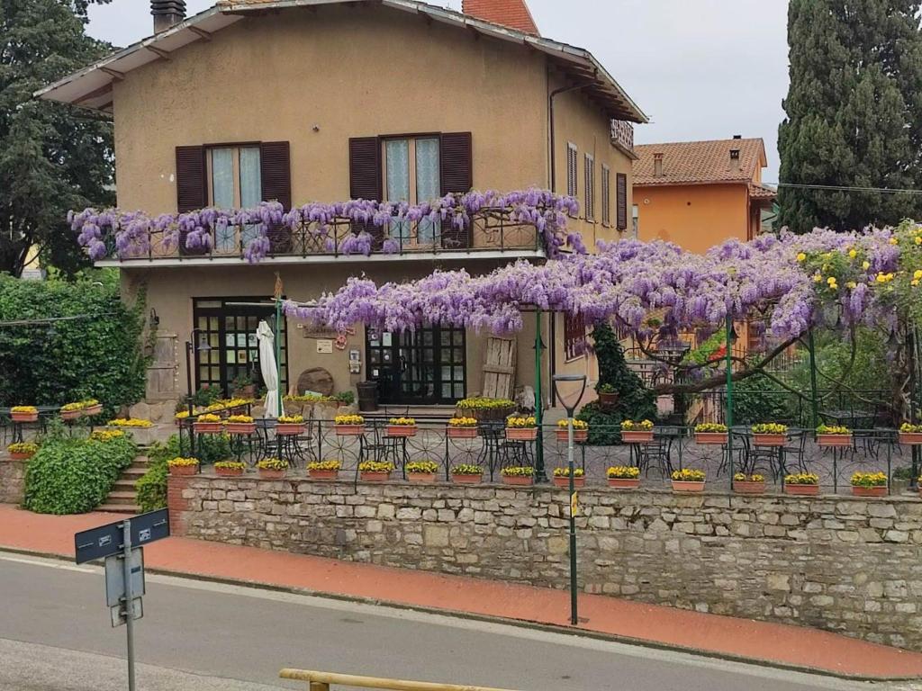 ein Haus mit lila Blumen auf der Seite in der Unterkunft Il Glicine - anemone in Paciano