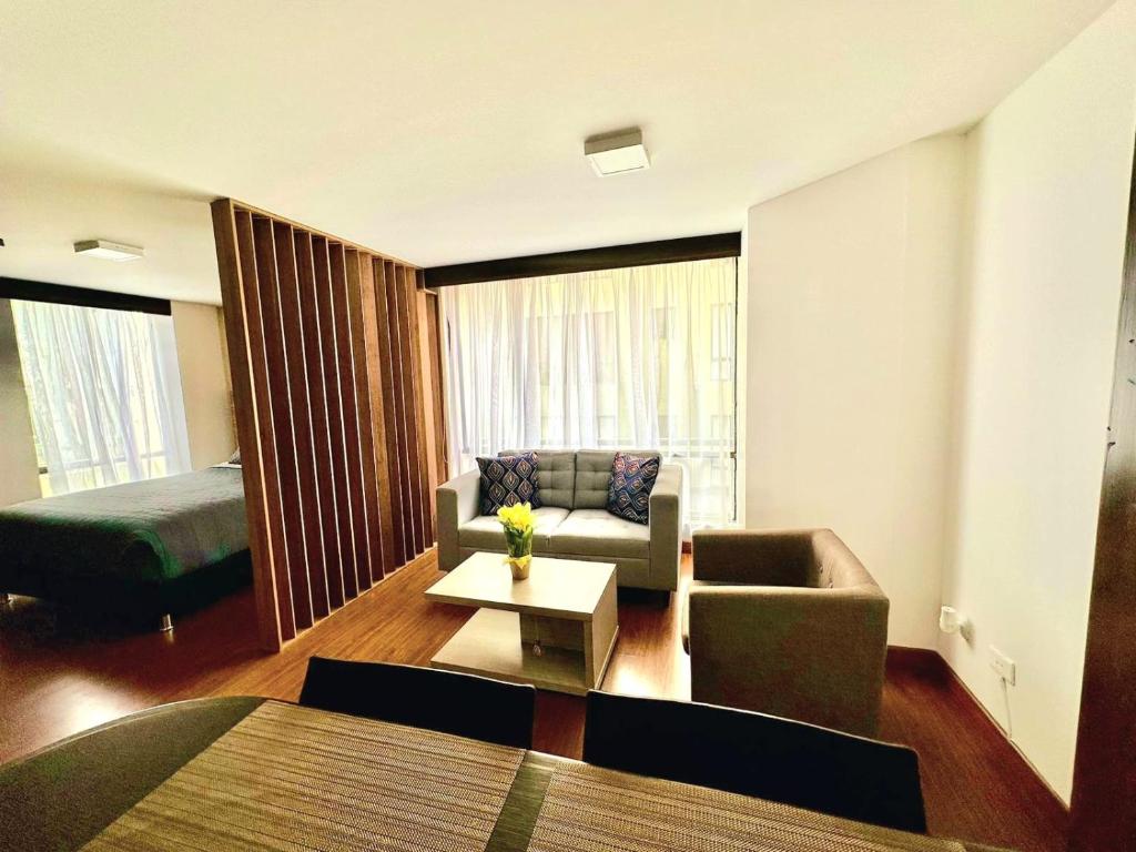sala de estar con sofá y cama en Cómodo Apartaestudio en super ubicación, en Bogotá
