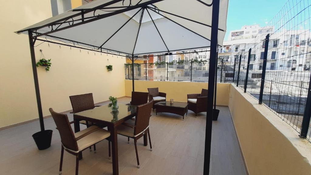 a table and chairs on a balcony with an umbrella at Residenza La Terrazza locazione turistica in Bari
