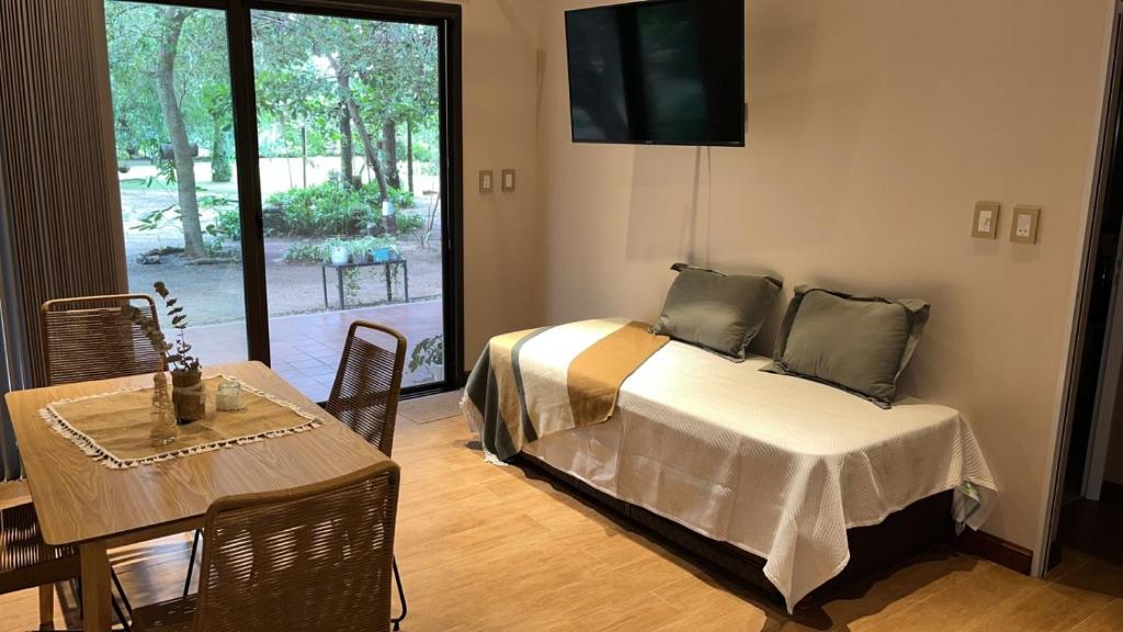 a bedroom with a bed and a table and a television at casa-quinta cerca de corrientes y santa ana in Corrientes