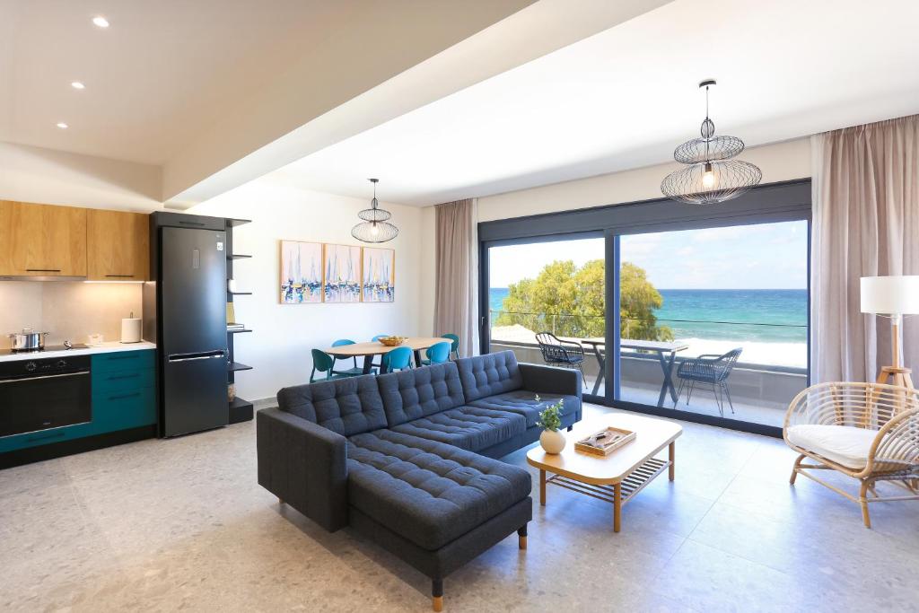 a living room with a couch and a table and a kitchen at Dione Seaside Apartments in Hersonissos