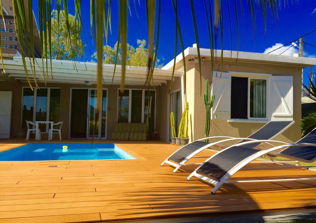 uma casa com piscina em frente a uma casa em Villas Hibiscus em La Gaulette