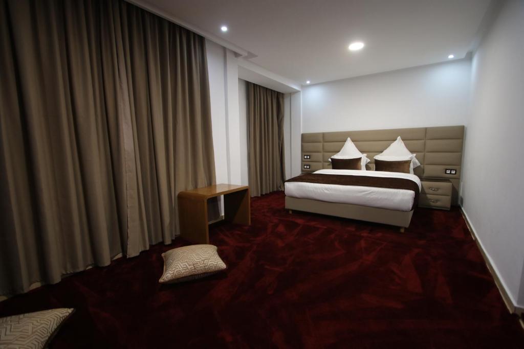 une chambre d'hôtel avec un lit et une table dans l'établissement Hôtel Mansour, à Dakhla