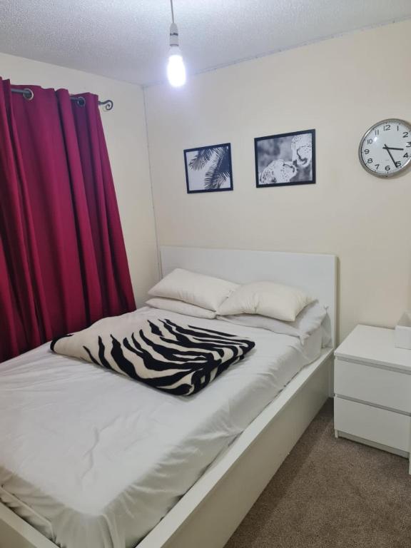 een slaapkamer met een bed met een zebradeken erop bij SOFT PILLOW in North Woolwich