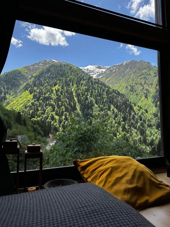 a bedroom with a large window with a mountain view at Ayder Dağ Evi in Ayder Yaylasi