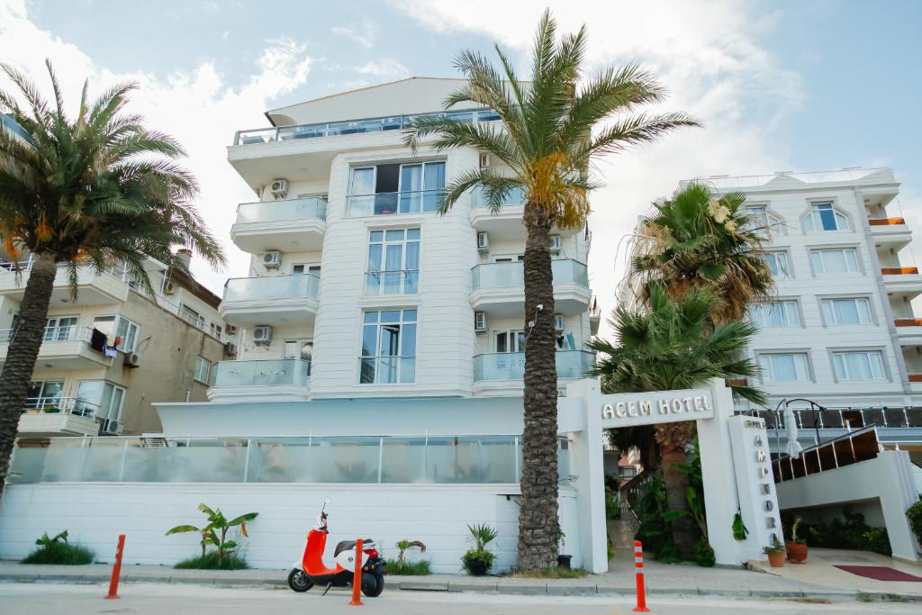 un scooter estacionado frente a un edificio en Acem Hotel, en Ayvalık