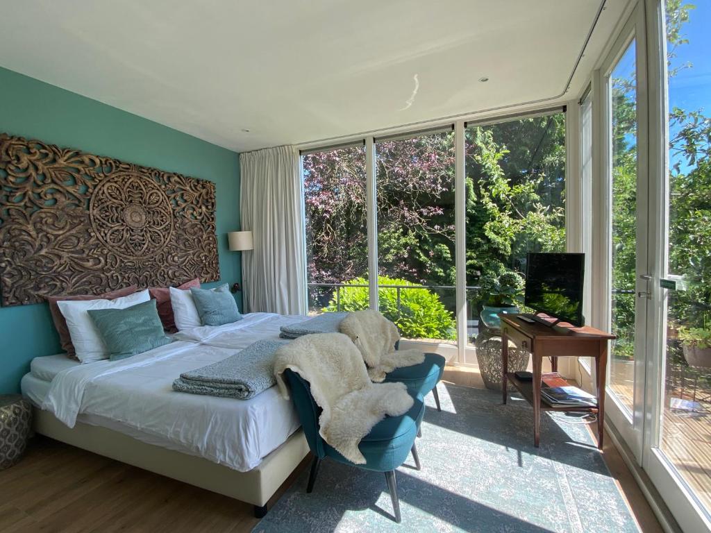 a bedroom with a bed and a large window at Appartement Osso Arnhem in Arnhem