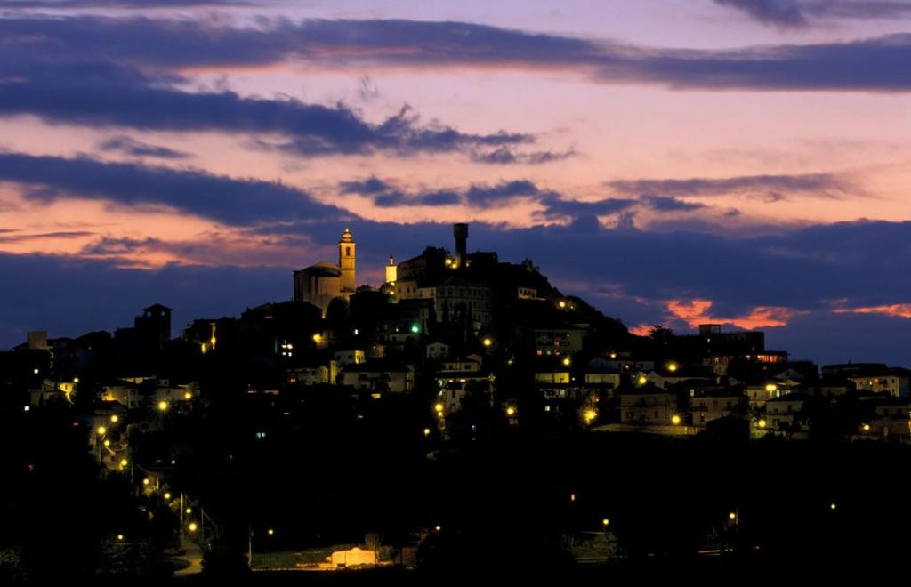 uma cidade iluminada à noite com uma cidade em Ferruccio's House em Colonnella