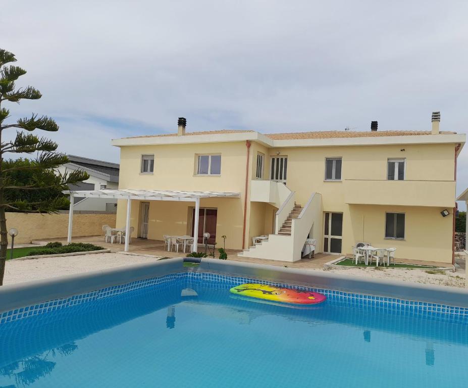 a villa with a swimming pool in front of a house at Mare e Storia da Sabrina in Sassari