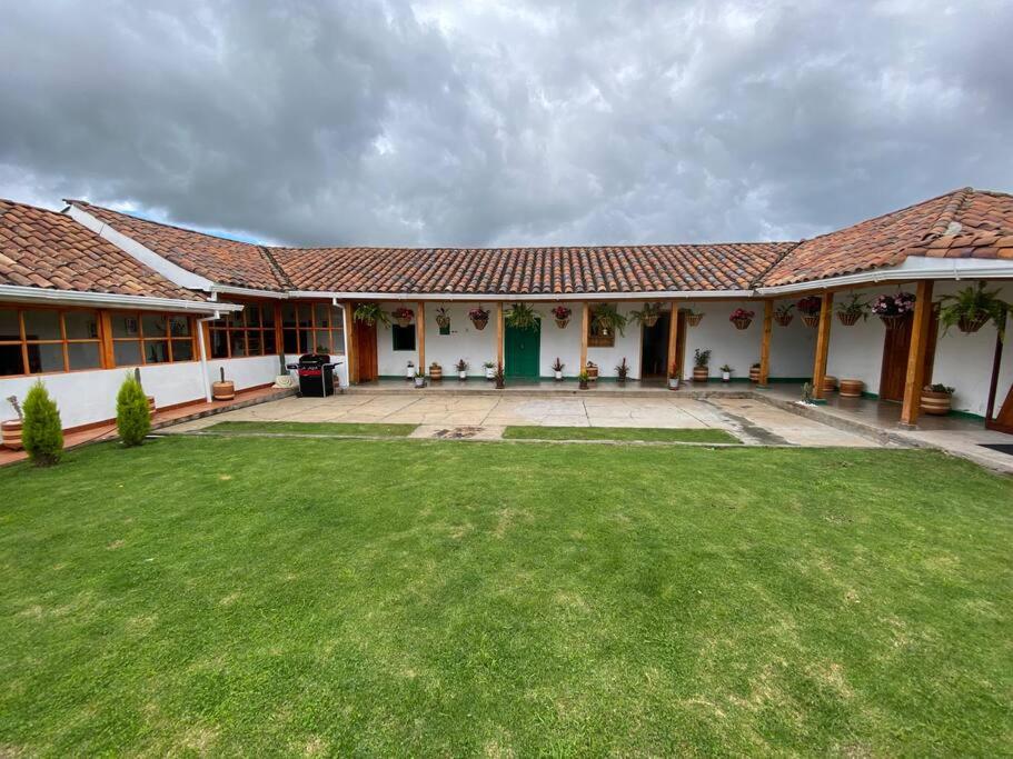 una casa con un césped verde delante de ella en Linda Casa Colonial Remodelada, en Guasca