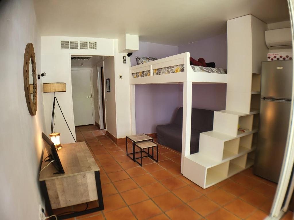 ein Zimmer mit zwei Etagenbetten und einer Couch in der Unterkunft studio colibri in Saint-François