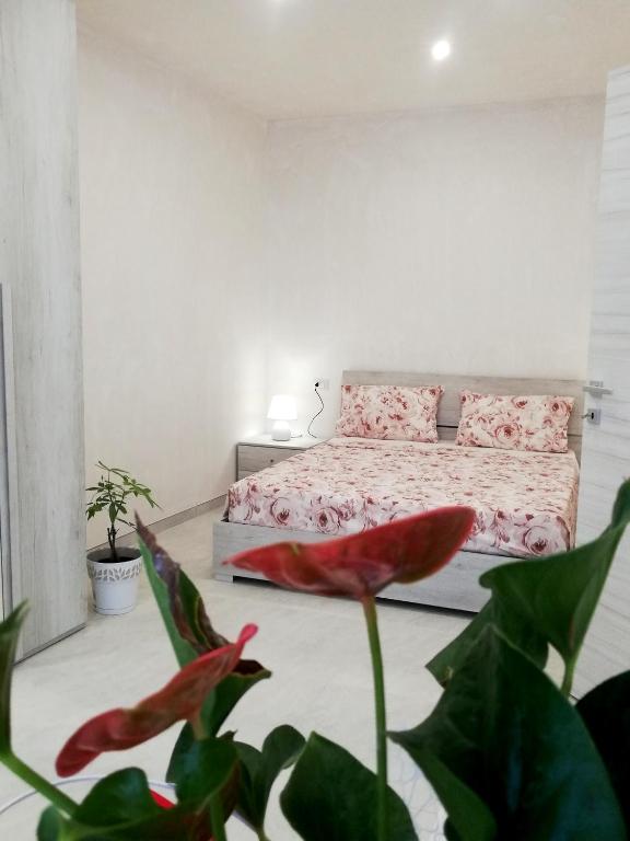 烏賈諾拉基耶薩的住宿－Casa Cinzia diamond 104，一间卧室,前方有一张带红花的床