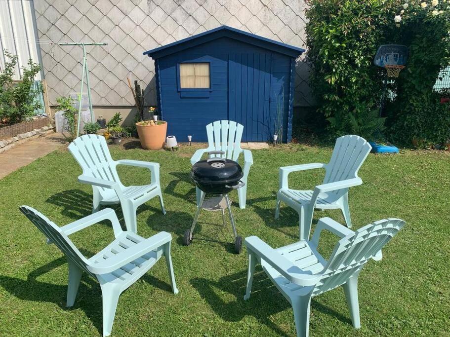 a group of four chairs and a grill in a yard at Bogota - maison familiale - tramway - Canal+&#47;sport in Le Mans