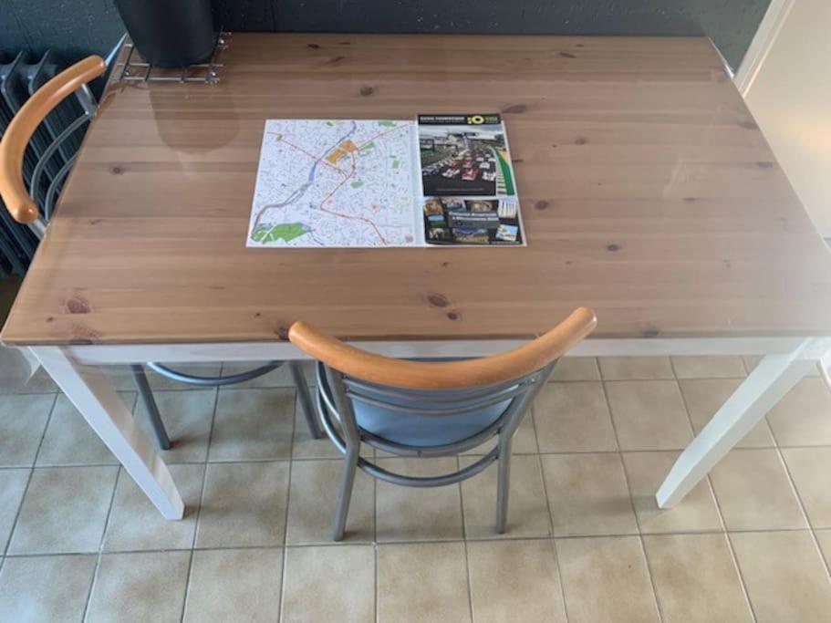 a wooden table with two chairs and a map at Bogota - maison familiale - tramway - Canal+&#47;sport in Le Mans