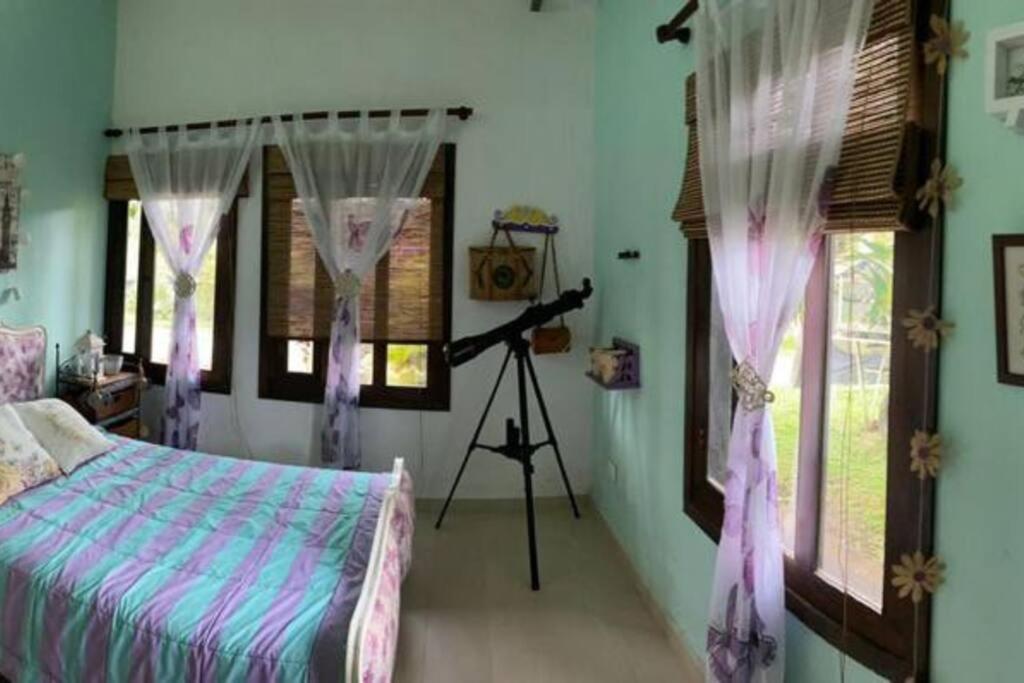 1 dormitorio con cámara, 1 cama y ventanas en Linda Casa Campestre, en Anolaima