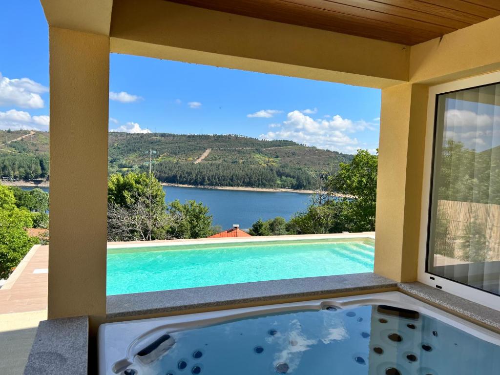 vistas a la piscina desde el balcón de una casa en Villa Gerês Emblematico - Piscina & Jacuzzi, en Venda Nova