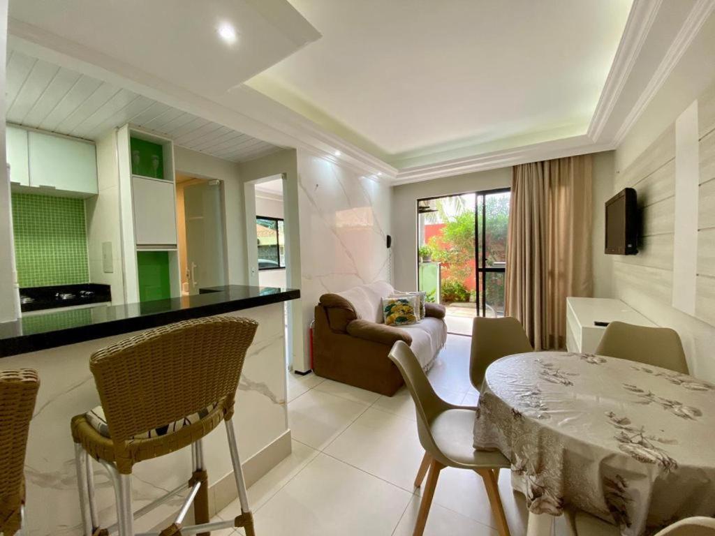 een keuken en een woonkamer met een tafel en stoelen bij Flat Crystal Park Porto das Dunas in Aquiraz