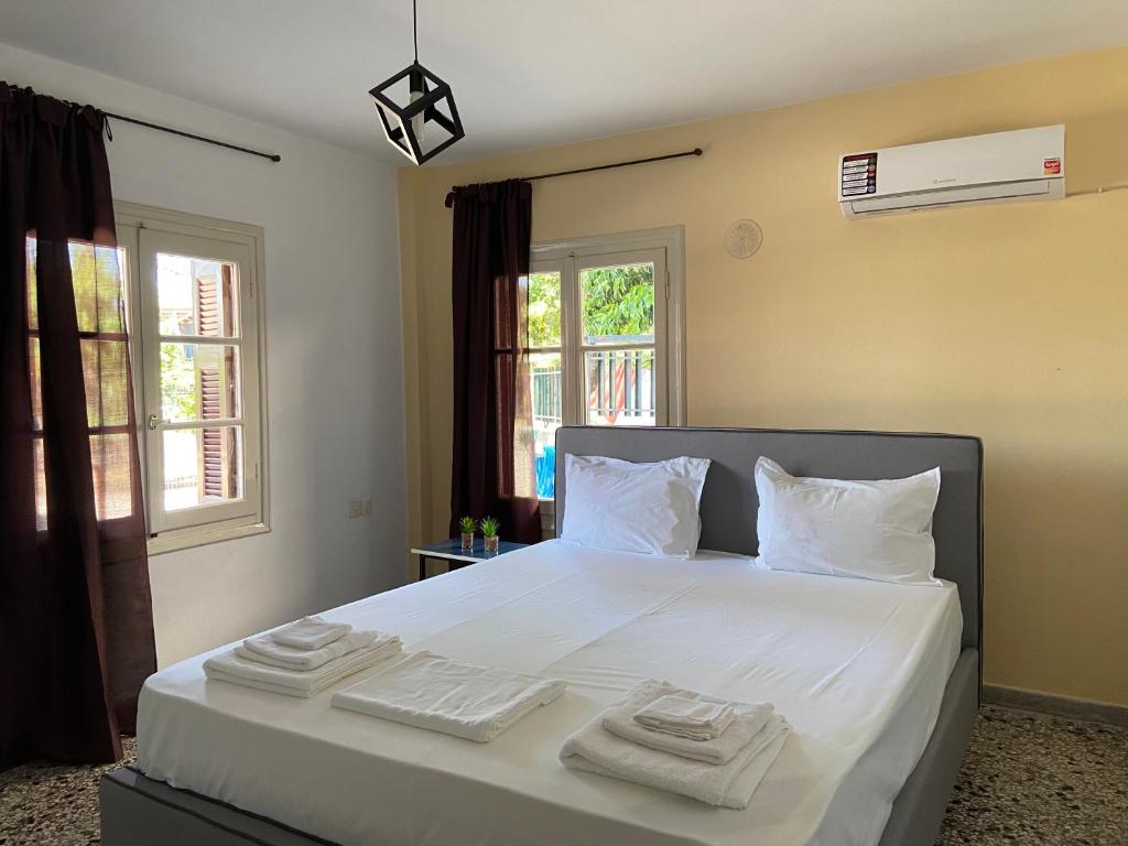 - une chambre avec un grand lit blanc et des serviettes dans l'établissement Family apartment with 2 bedrooms to the city center, à Kamena Vourla