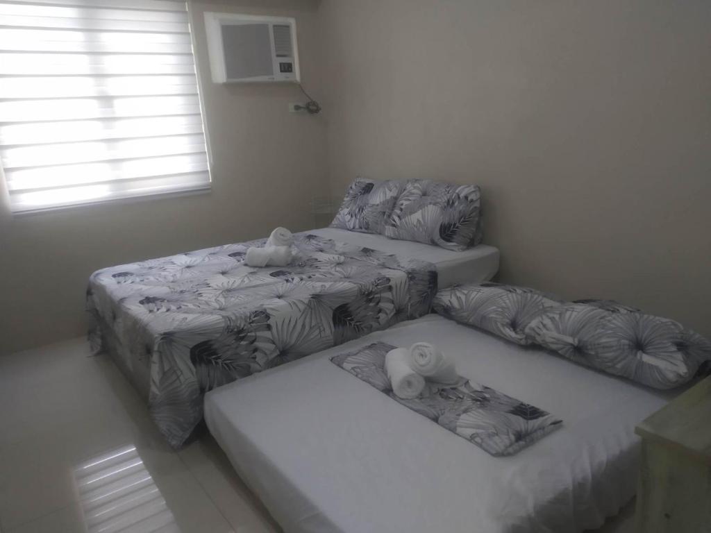 Zimmer mit 3 Betten und einem Fenster in der Unterkunft Sunvida Tower Across SM City Cebu in Cebu City