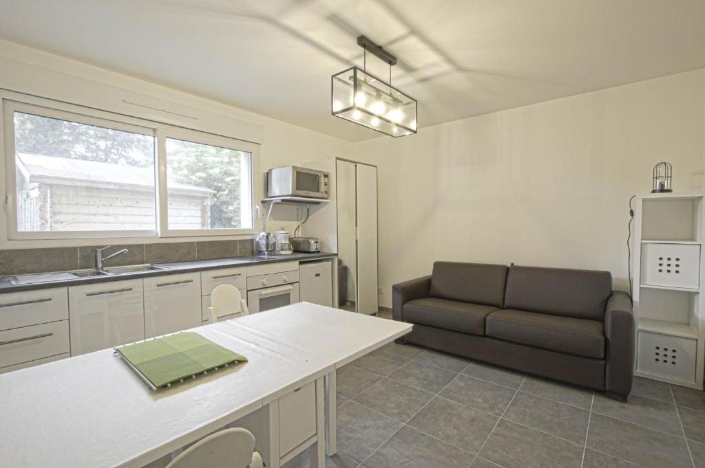 eine Küche mit einem Sofa und einem Tisch in einem Zimmer in der Unterkunft Gold Beach Studio in Tracy-sur-Mer