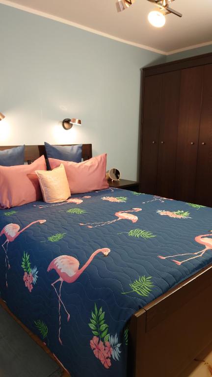 ein Schlafzimmer mit einem großen Bett mit rosa Flamingos darauf in der Unterkunft Druskininkų Pasaga in Druskininkai
