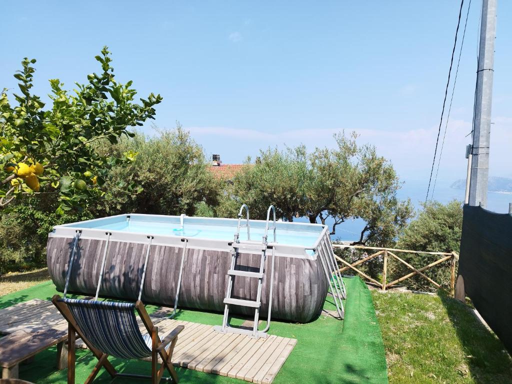 a pool with a ladder and a chair in a backyard at La Terrazza in Gioiosa Marea