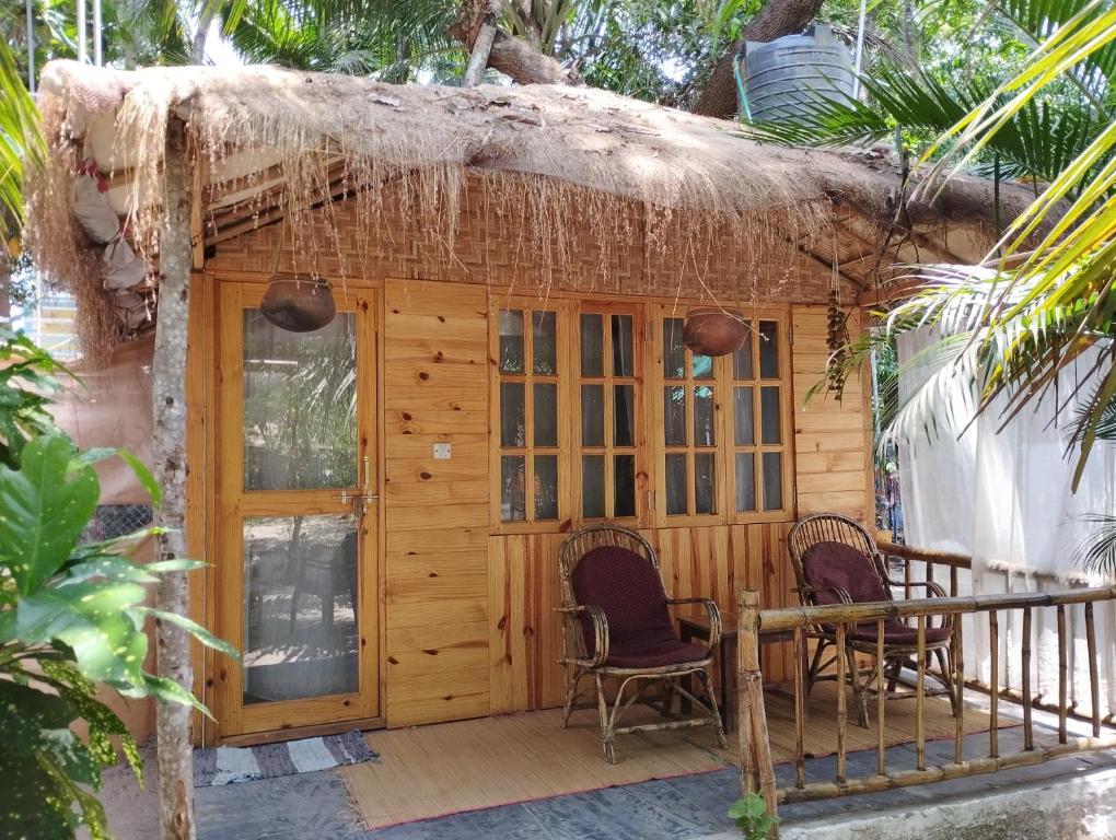 eine kleine Hütte mit zwei Stühlen auf einer Terrasse in der Unterkunft Yoga Culture Palolem in Palolem