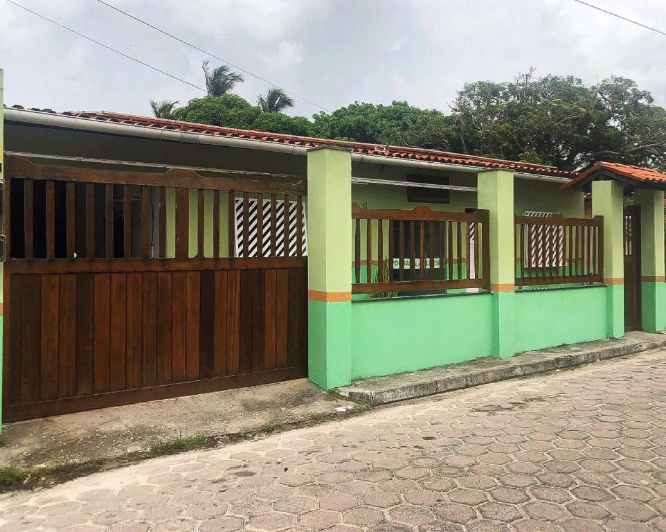 una casa con una puerta de madera en una calle en Pousada Palmeiras en Santo Amaro