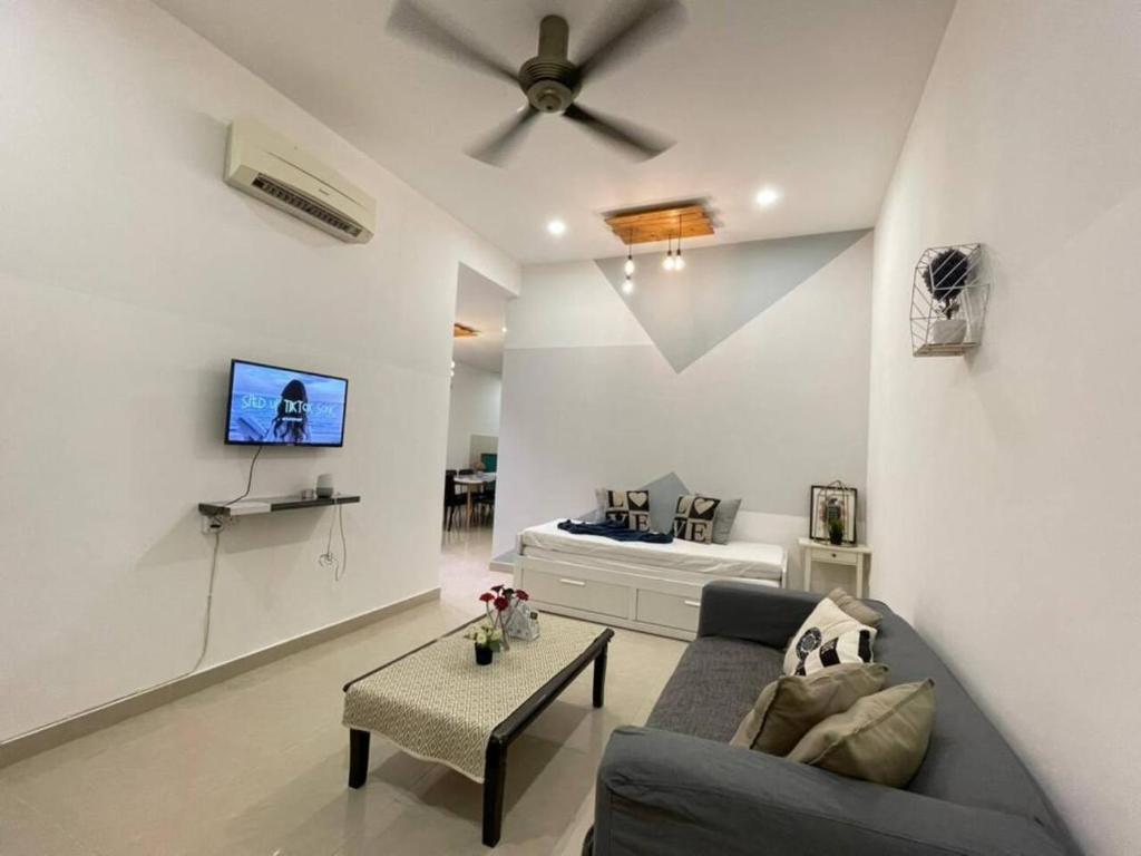 a living room with a couch and a ceiling fan at Cozy 119 Homestay Teluk Intan in Teluk Intan