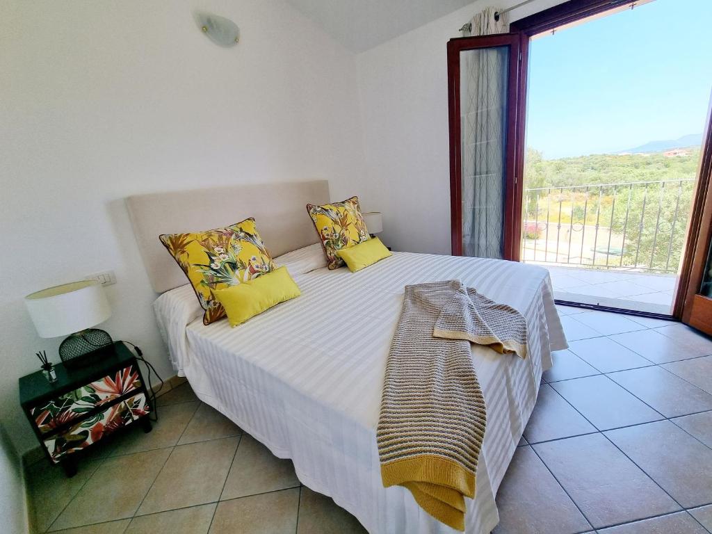 a bedroom with a bed with yellow pillows and a window at Residenza Porto Istana in Murta Maria