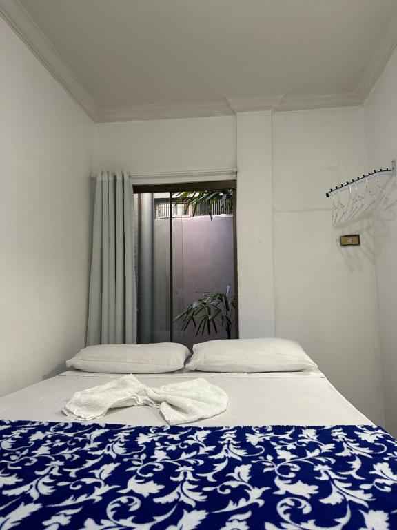 1 dormitorio con 1 cama con manta azul y blanca en Espaço completo bem localizado c estacionamento, en Foz do Iguaçu