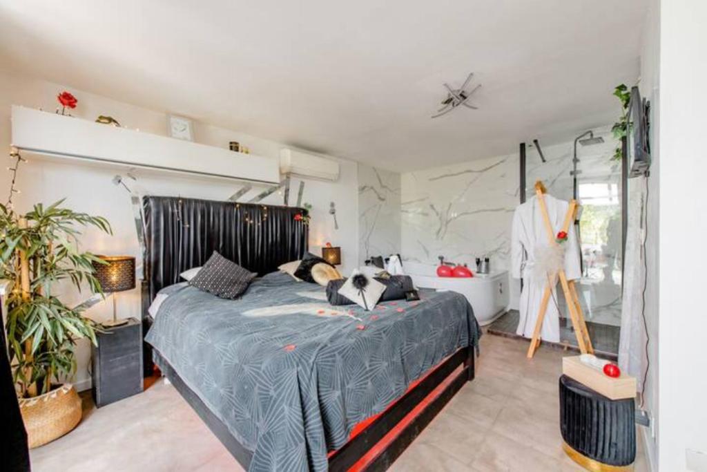 een slaapkamer met een bed en een mannequin bij coconbleu, balnéo double in Solliès-Toucas