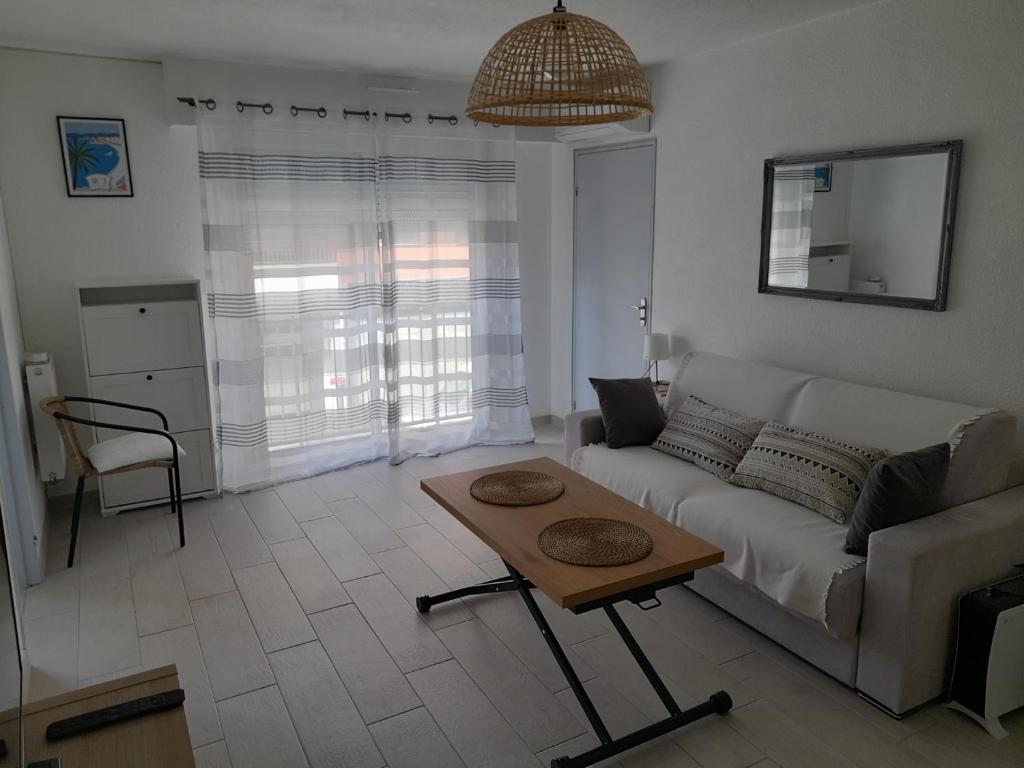 a living room with a couch and a table at F1 à 5 minutes des plages et de la gare in Vallauris