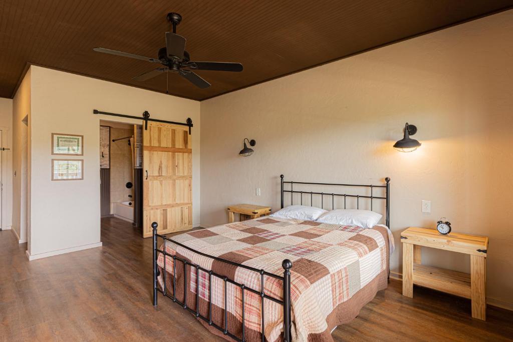 a bedroom with a bed and a ceiling fan at Miners Cabin #2 - One Queen Bed - Accessible Room - Private Balcony in Tombstone