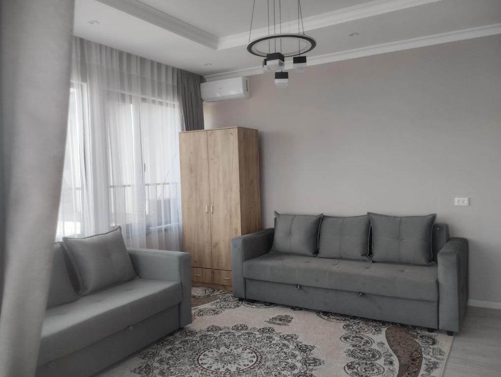 Таунхаус في بيشكيك: غرفة معيشة مع أريكة وكرسي