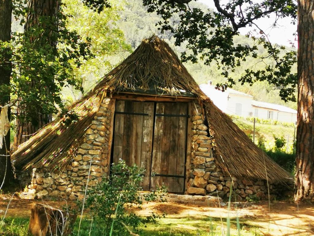 a small stone building with a grass roof at La Bastide du Capelier - Cabane in Salernes