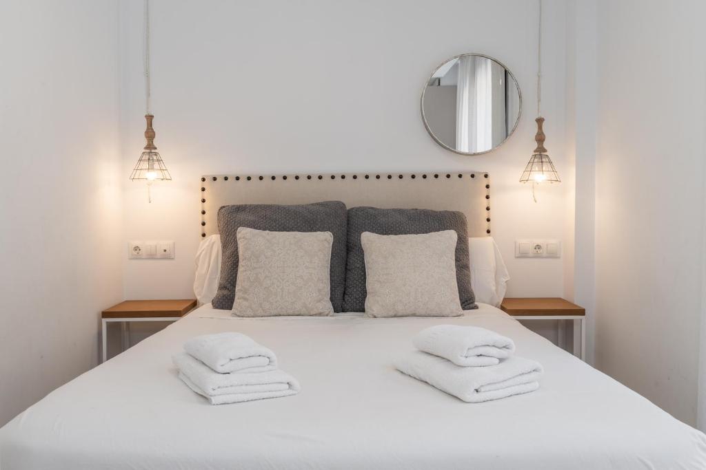 - une chambre avec un lit blanc et 2 serviettes dans l'établissement tuGuest Gran Vía Apartments, à Grenade