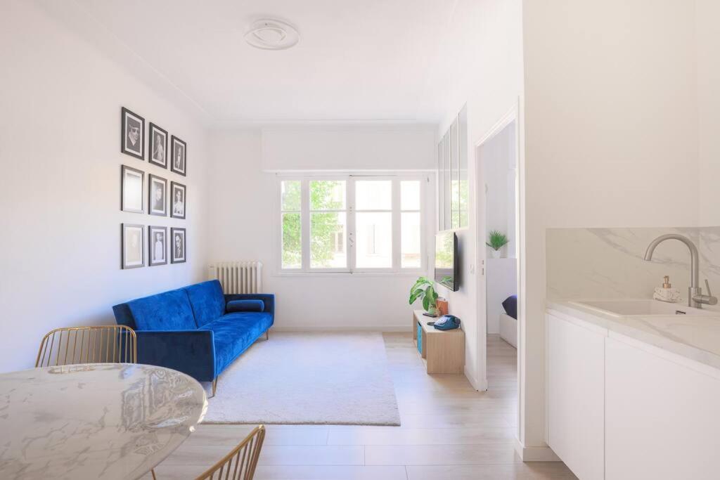 - un salon avec un canapé bleu et un lavabo dans l'établissement Paca Properties - 2MD - Beau T2, à Cannes