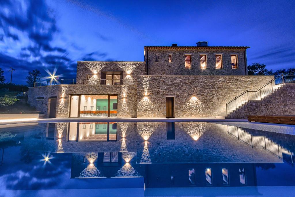 una casa de piedra con piscina por la noche en Agriturismo Colli Martani en Massa Martana