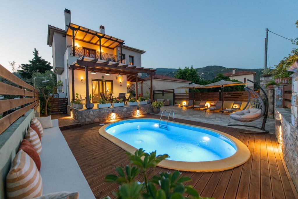 un patio trasero con piscina y una casa en Villa Fylira, en Kato Gatzea