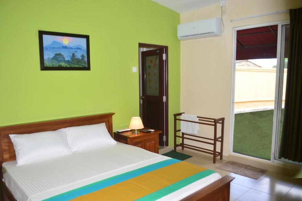 ein Schlafzimmer mit einem Bett und einem großen Fenster in der Unterkunft Paramount Residence 3 in Kelaniya