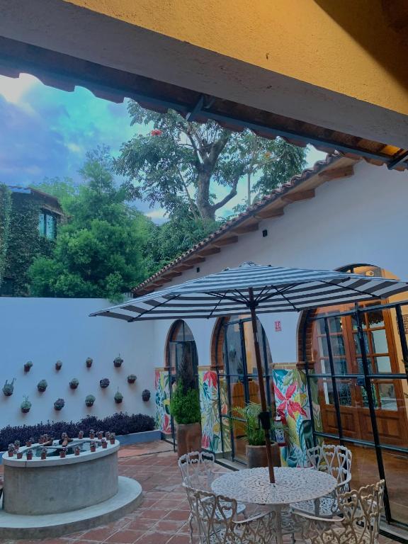 a patio with two tables and an umbrella at Sierra Norte By Chic Hotel Group in Tepoztlán
