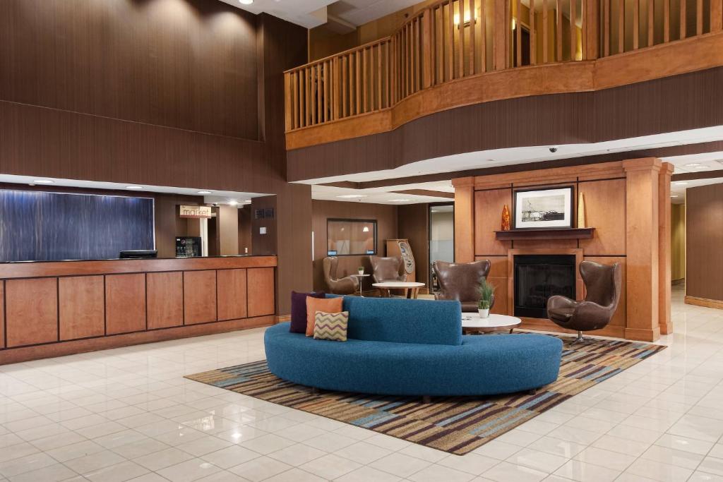 a lobby with a blue couch and a fireplace at Fairfield Inn and Suites Atlanta Airport South/Sullivan Road in Atlanta