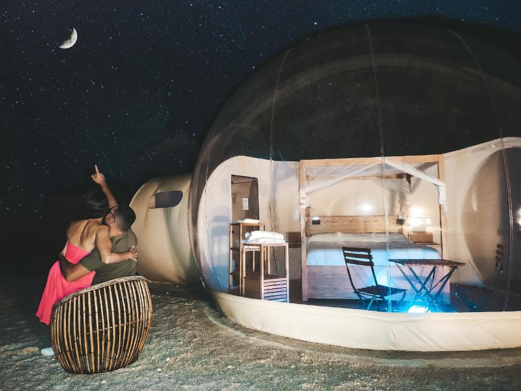 a woman is sitting on a barrel in a round house at Hotel Zielo Las Beatas in Santa Maria