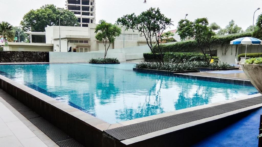 a large swimming pool with blue water in a building at Apartemen Altiz Bintaro J in Mencil