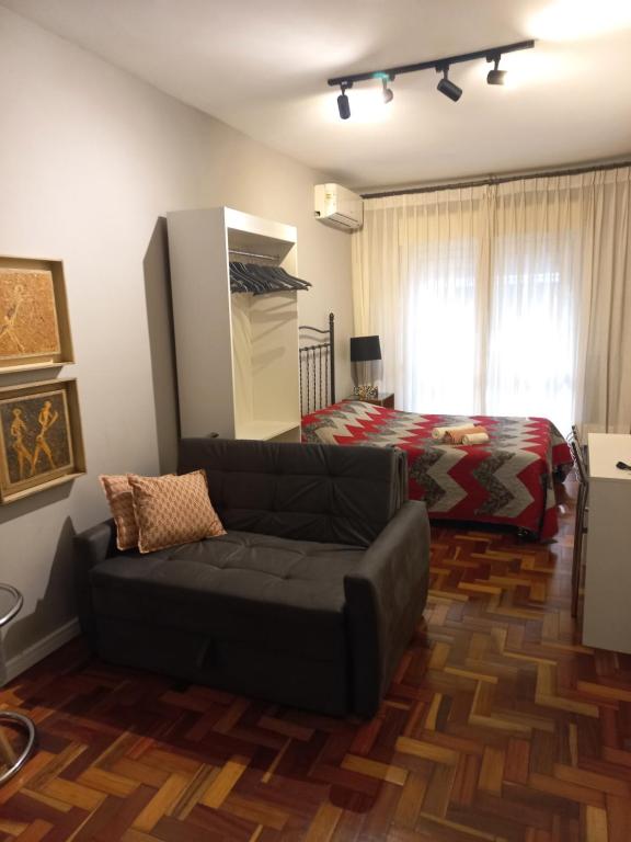 a living room with a couch and a bed at Studioaconchegantepoa in Porto Alegre
