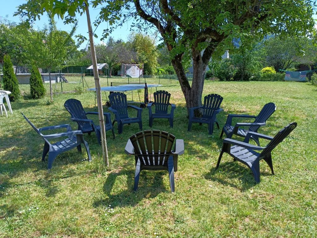 a group of chairs sitting around a table under a tree at L&#39;échappée Comtoise in Baume-les-Dames